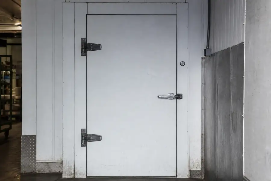 Sealed walk-in cooler door closing flush against its frame after hardware repair